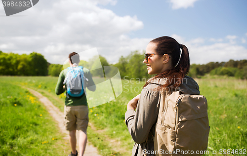 Image of happy couple with backpacks hiking outdoors