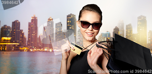 Image of happy woman with credit card and shopping bags