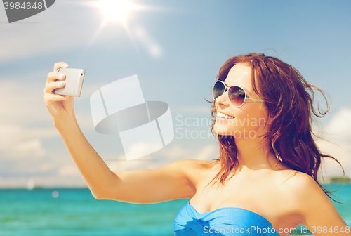 Image of woman in bikini with phone