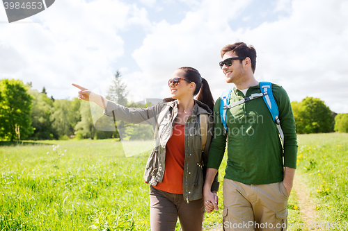 Image of happy couple with backpacks hiking outdoors