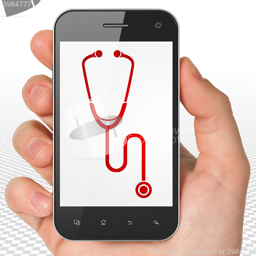 Image of Health concept: Hand Holding Smartphone with Stethoscope on display