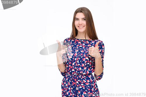 Image of Happy smiling beautiful young brunette woman showing thumbs up gesture