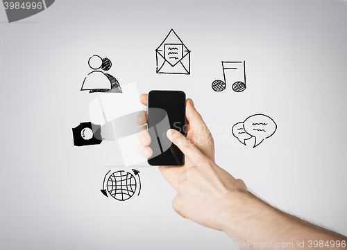 Image of close up of hands with smartphone and doodles