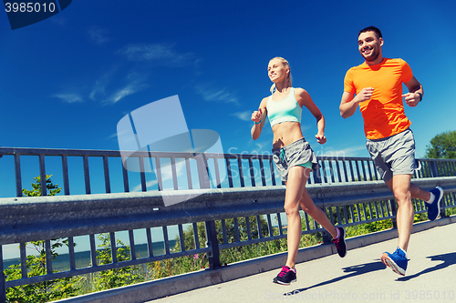 Image of smiling couple running at summer seaside