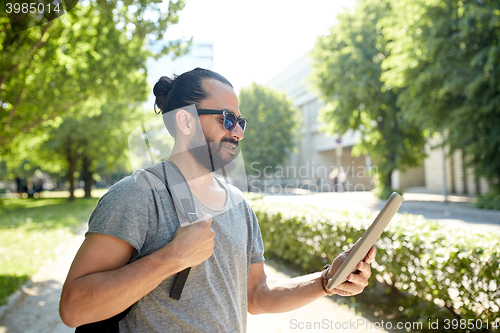 Image of man traveling with backpack and tablet pc in city