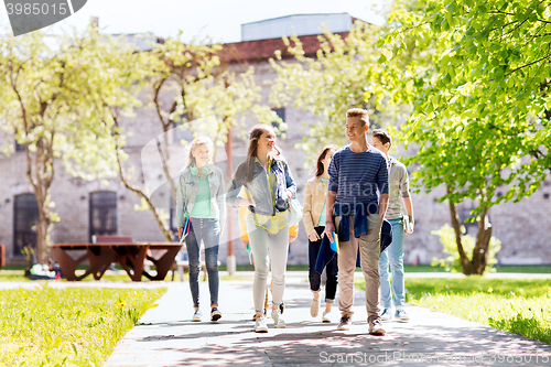 Image of group of happy teenage students walking outdoors