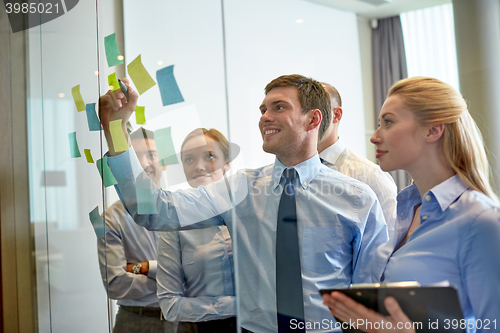 Image of smiling business people with marker and stickers