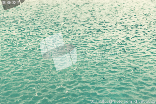 Image of water surface with raindrops at rainy day