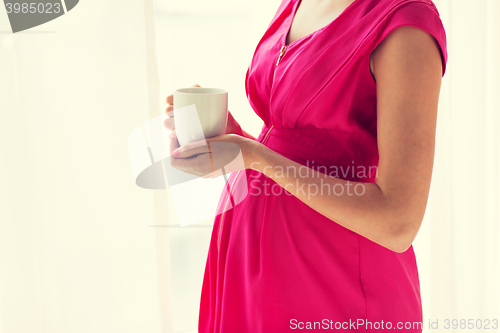 Image of pregnant woman with cup drinking tea at home