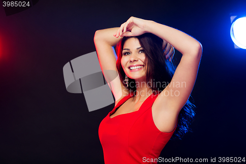 Image of beautiful sexy woman in red dancing at nightclub