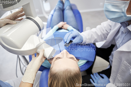 Image of dentist and patient with dental x-ray machine