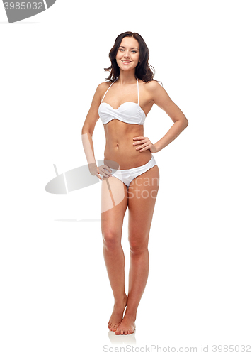 Image of happy young woman in white bikini swimsuit