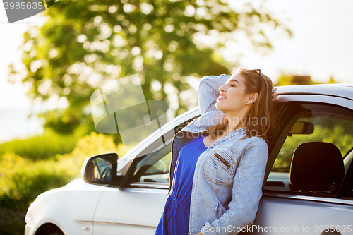 Image of happy teenage girl or young woman in car