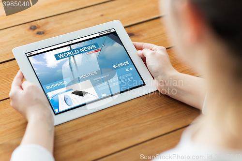 Image of close up of woman with tablet pc on wooden table