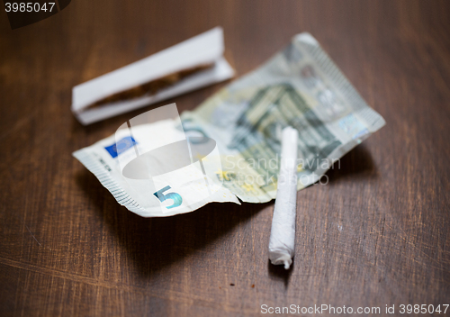 Image of close up of marijuana joint and money