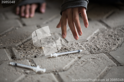 Image of close up of addict woman hands and drug syringes