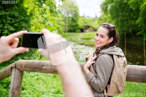 Image of couple with backpacks taking picture by smartphone