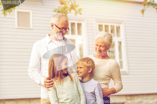 Image of happy family in front of house outdoors