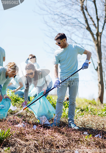 Image of volunteers with garbage bags cleaning park area