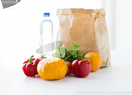 Image of close up of paper bag with vegetables and water