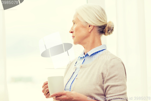 Image of lonely senior woman with cup of tea or coffee