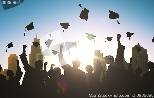 Image of silhouettes of students throwing mortarboards