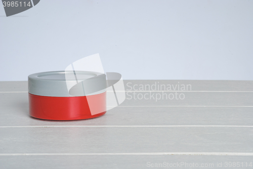Image of tib of face cream with red cover