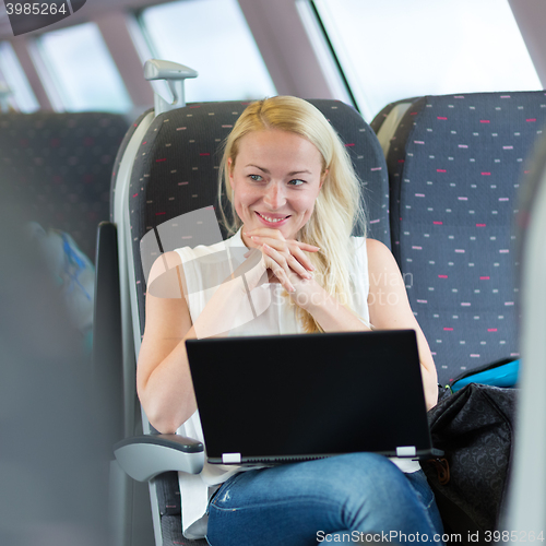 Image of Woman smiling while travelling by train.