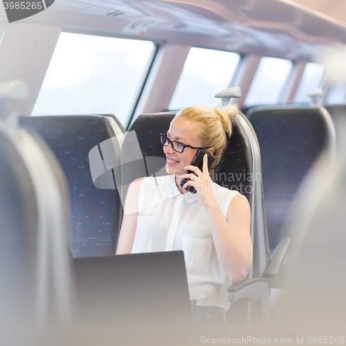 Image of Business woman working while travelling by train.