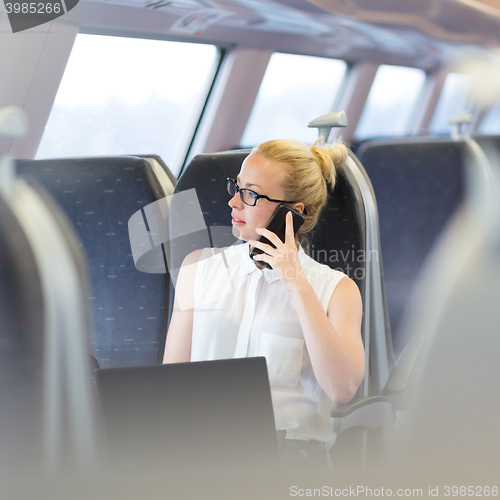 Image of Business woman working while travelling by train.