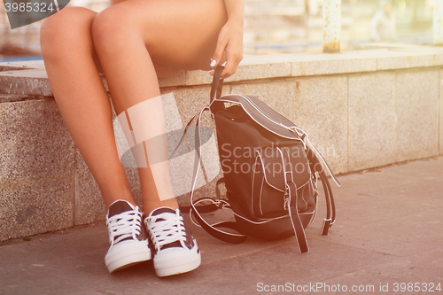 Image of closeup of woman legs in white gumshoes