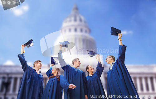 Image of group of happy students waving mortarboards