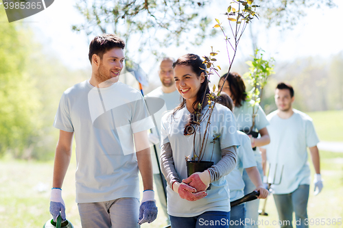 Image of group of volunteers with trees and rake in park