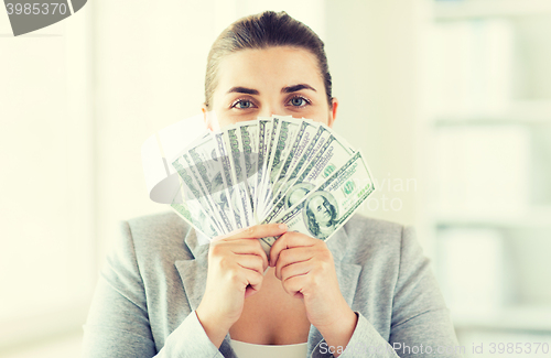 Image of woman hiding her face behind us dollar money fan