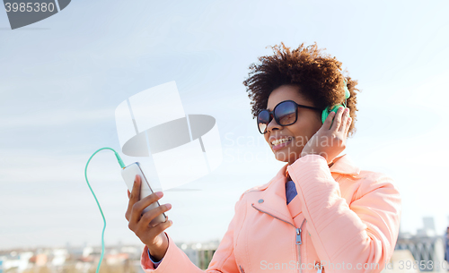 Image of happy young woman with smartphone and headphones