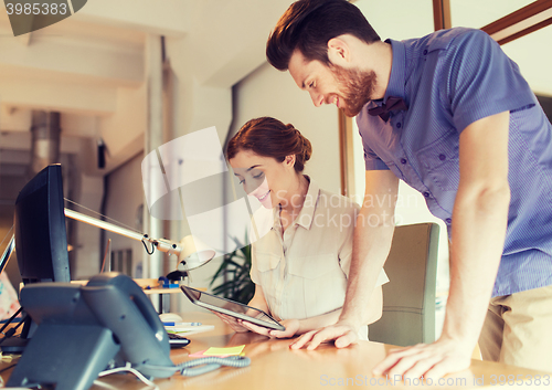 Image of happy creative team with tablet pc in office