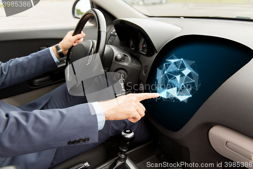 Image of man driving car and pointing to on-board computer