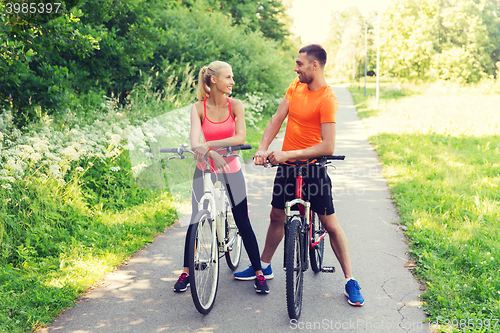 Image of happy couple riding bicycle outdoors