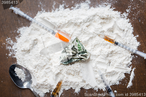 Image of close up of cocaine drug, money, spoon and syringe