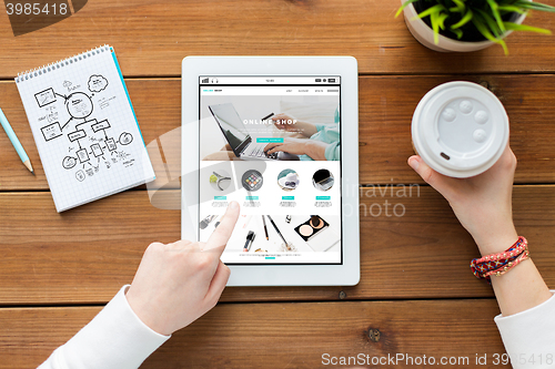 Image of close up of woman with tablet pc on wooden table