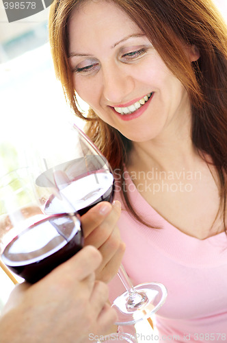 Image of Mature woman toasting with red wine