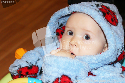 Image of little baby in dressing gown with amazed sight