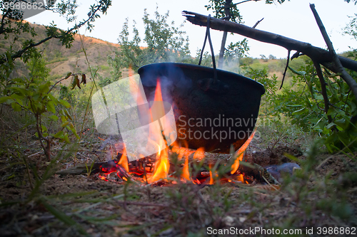 Image of Camp life. On fire to boil pot of soup for traveler