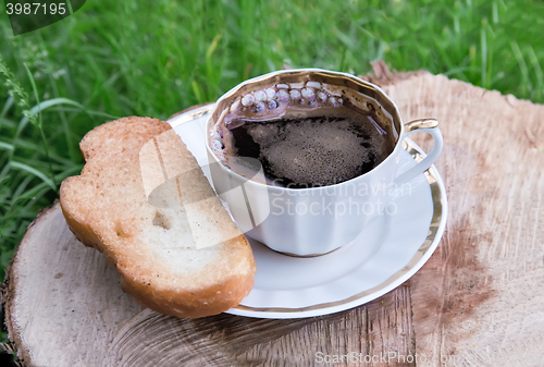 Image of Still life: a Cup of black coffee in the garden.