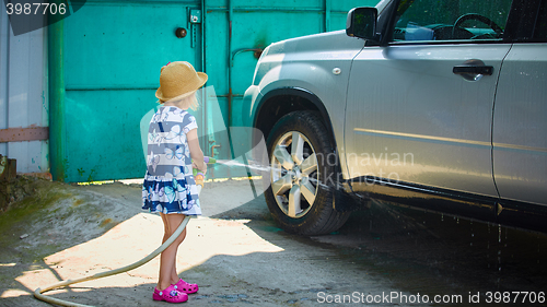 Image of Little girl helps her parents to wash the car