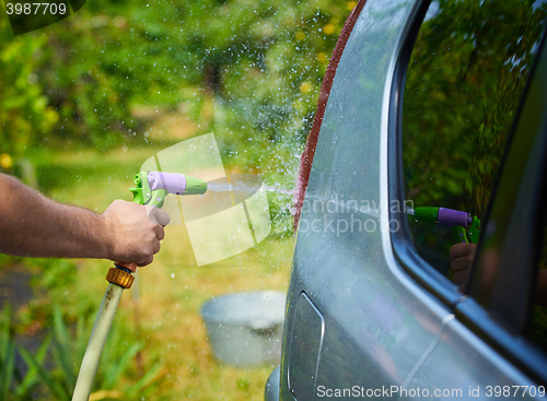 Image of People cleaning car using high pressure water