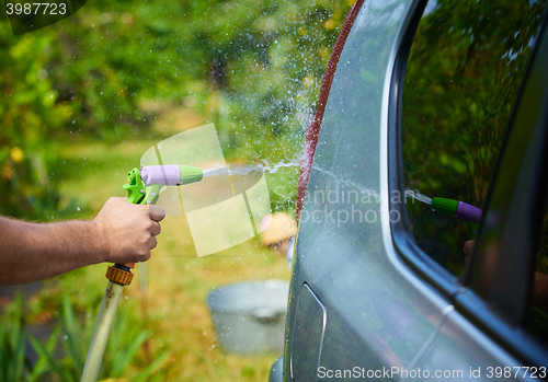 Image of People cleaning car using high pressure water