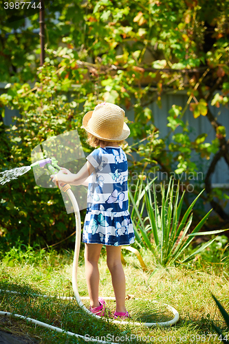 Image of Little happy girl watering garden