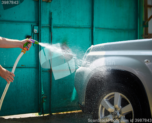 Image of People cleaning car using high pressure water