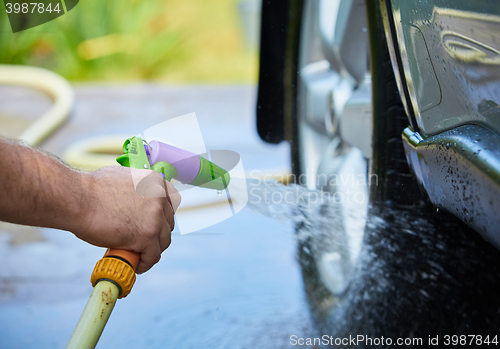 Image of People cleaning car using high pressure water